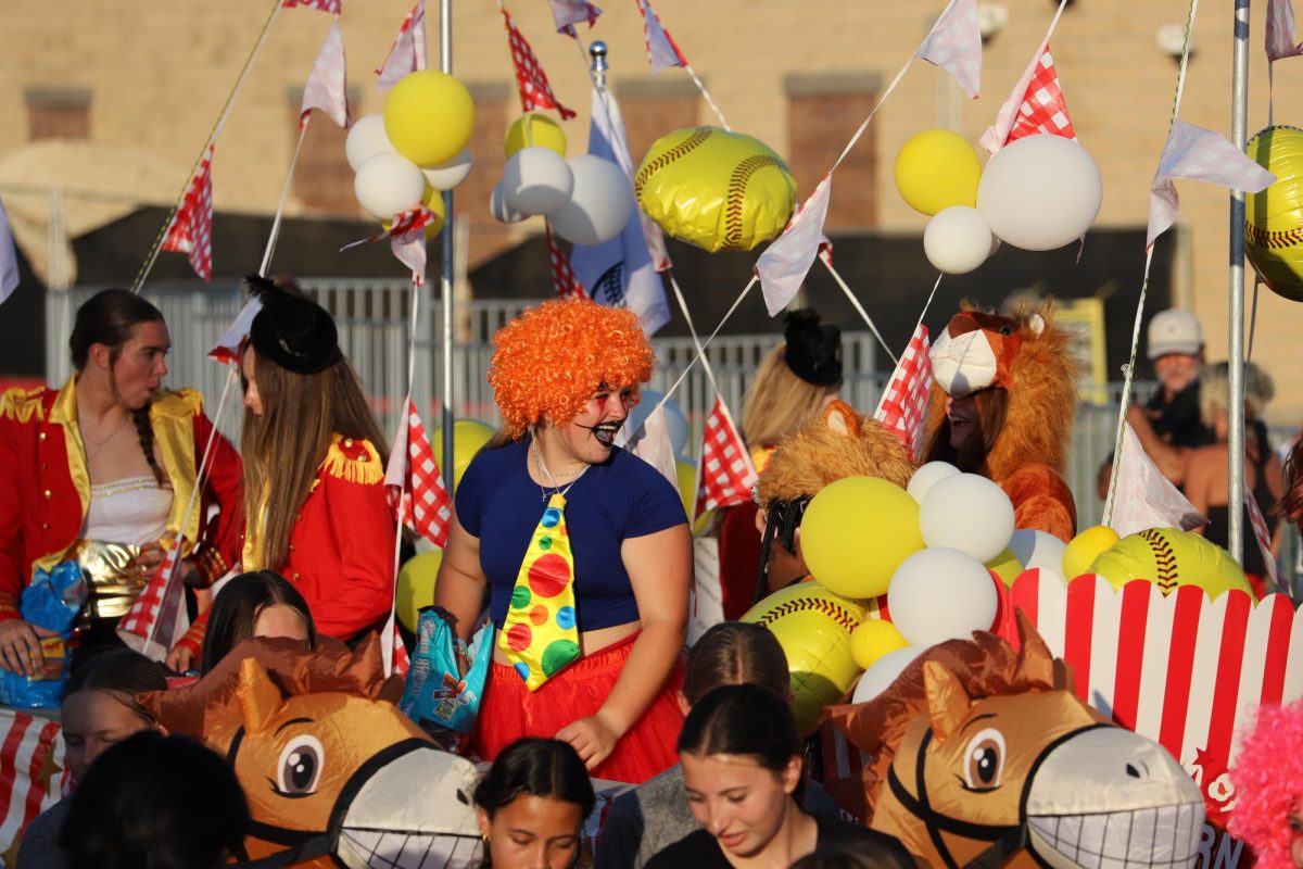 The Girls' Lacrosse team throws candy to the crowd aboard their circus-themed homecoming float at Wednesday's parade.